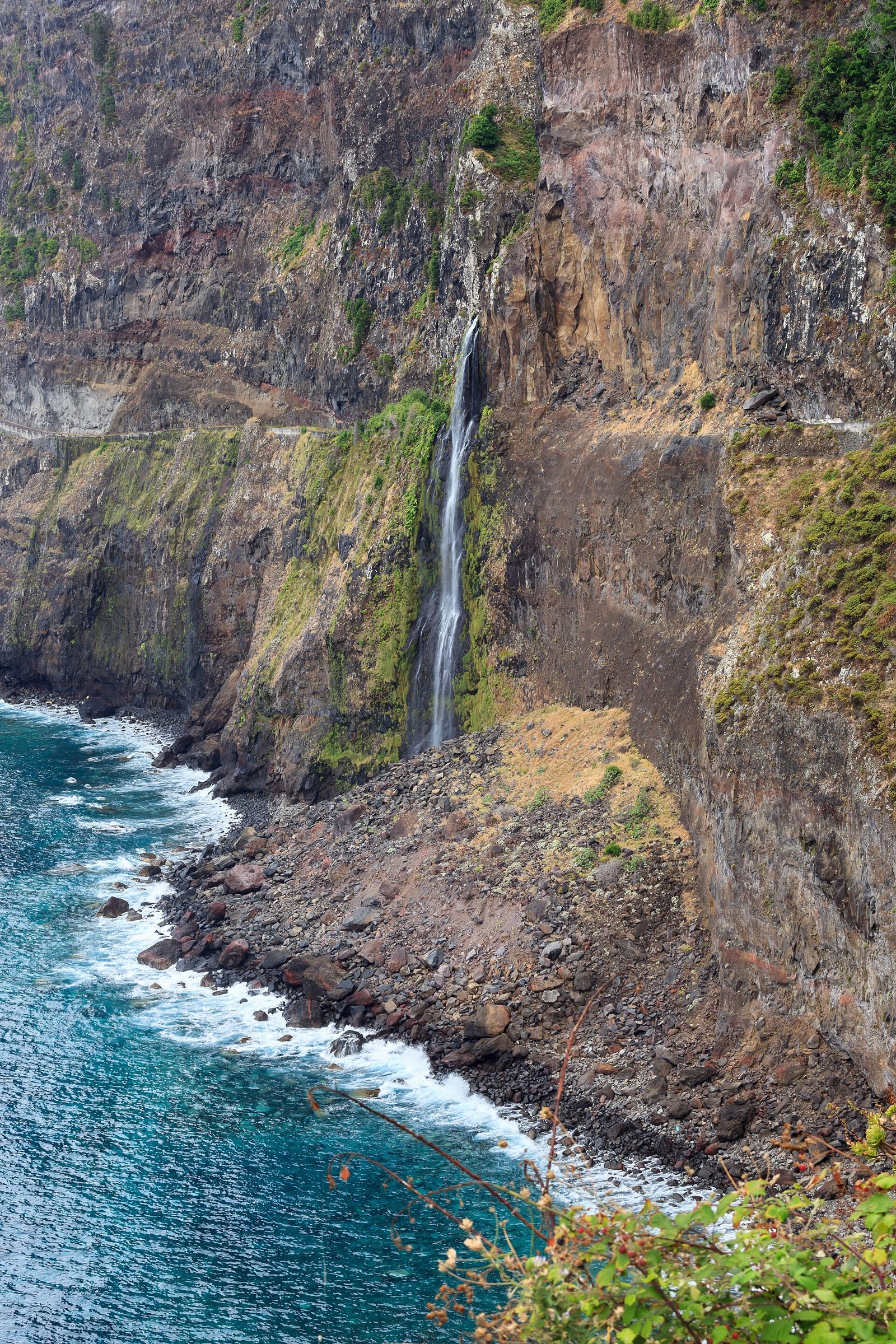 Tall waterfall falling down a sea cliff into the Atlantic near Seixal