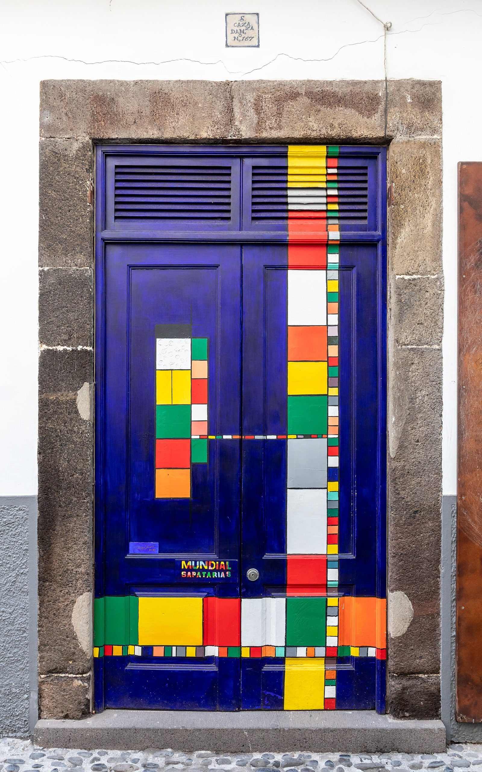 Narrow lane of painted doorways on Rua de Santa Maria in Funchal's old town