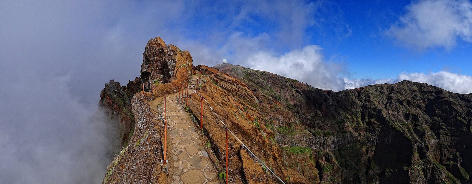 Stone stairway cut into a knife-edge mountain ridge on the PR1 trail