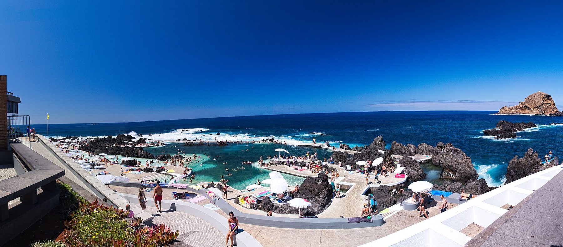 Turquoise volcanic natural pools surrounded by black lava rock